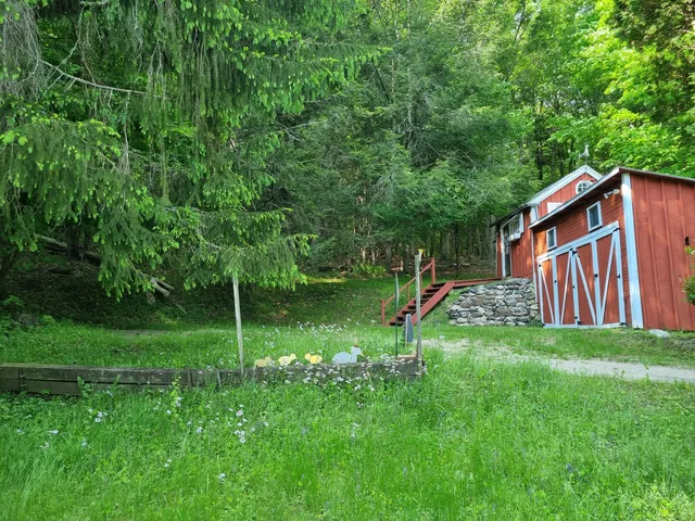a backyard of a house with plants and wooden fence