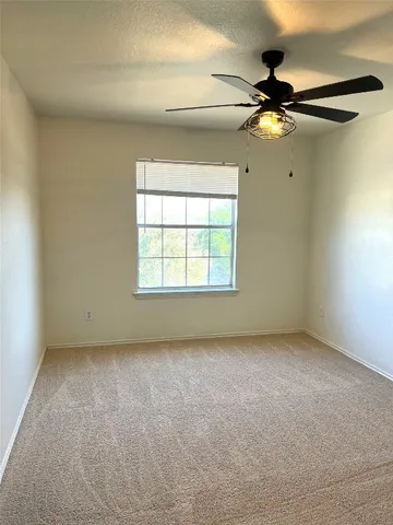 a view of a big room with windows and chandelier fan