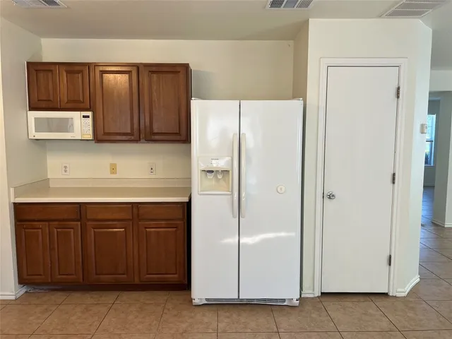 a kitchen with a refrigerator and cabinets