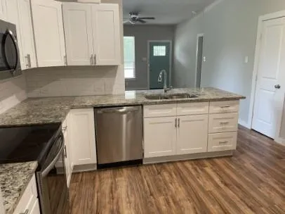 a kitchen with granite countertop a sink and cabinets