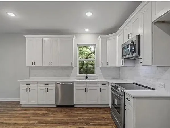 a kitchen with stainless steel appliances granite countertop a sink stove and cabinets