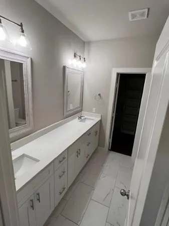 a bathroom with a double vanity sink and mirror