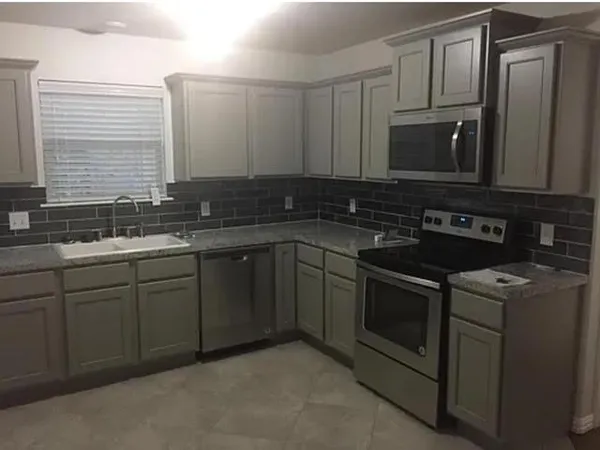 a kitchen with stainless steel appliances granite countertop a sink stove and microwave