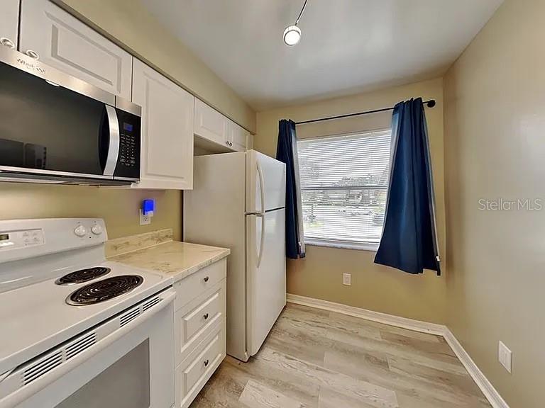 3260 Candle Ridge Drive, Unit 202 Orlando, FL 32822 - Photo 2 of 19 a kitchen with a refrigerator and a stove