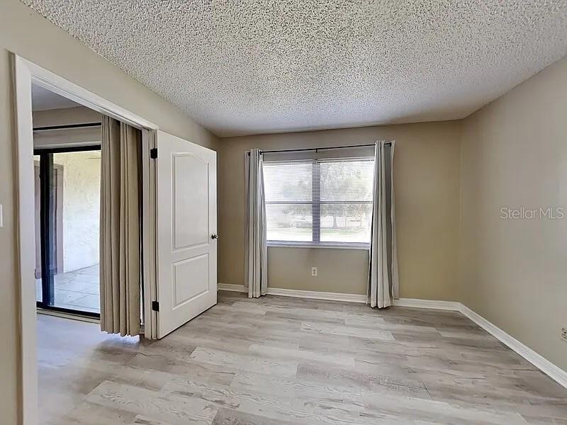 3260 Candle Ridge Drive, Unit 202 Orlando, FL 32822 - Photo 3 of 19 a view of an empty room with wooden floor and a window