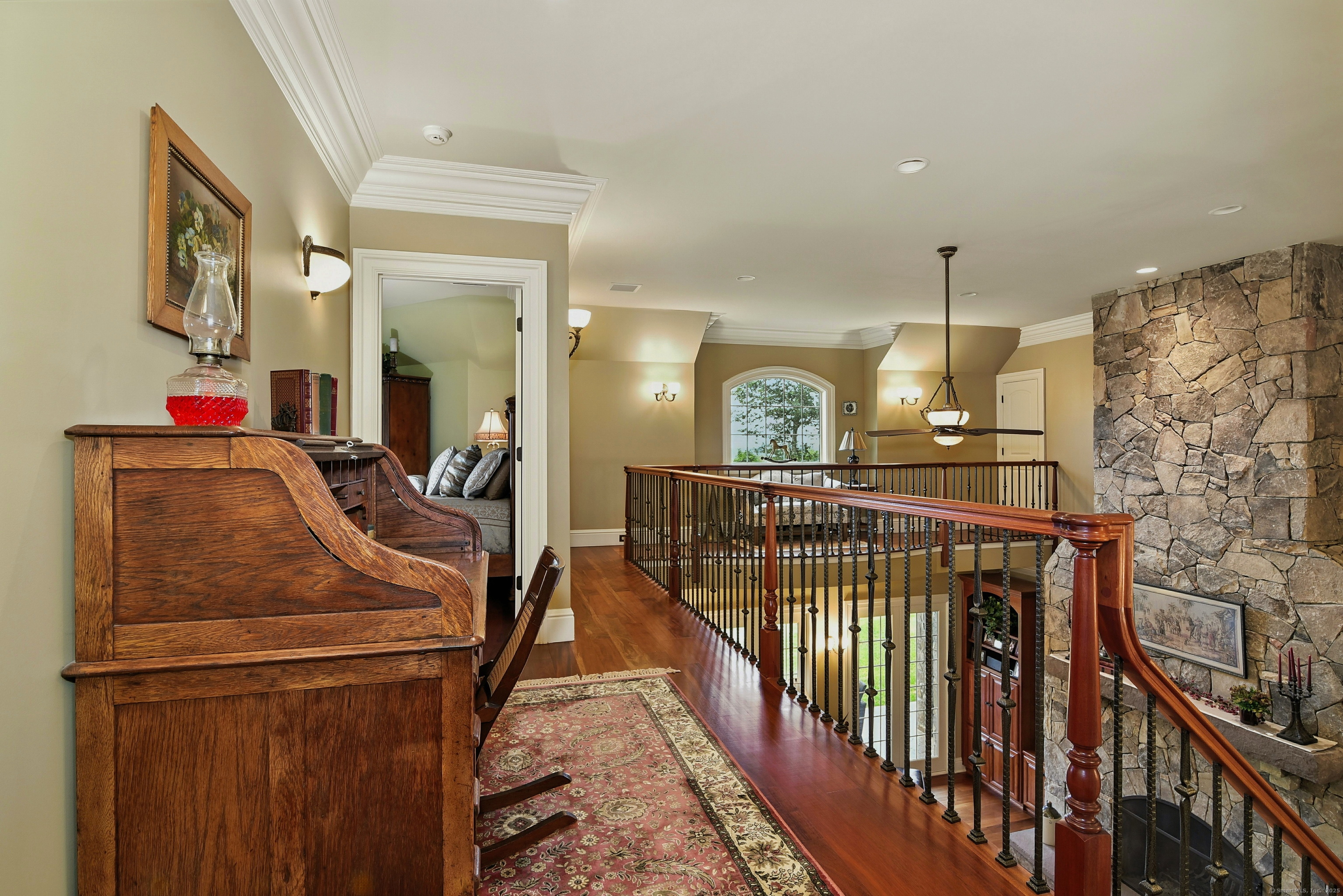 282 Searles Road Pomfret, CT 06259 - Photo 35 of 40 The balcony showcases the 5-inch mahogany floor, 12" triple crown molding, wrought-iron balusters with a polished handrail and the dramatic height of the fireplace and ceiling.