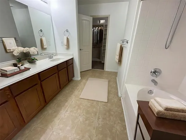 a bathroom with a tub sink and mirror