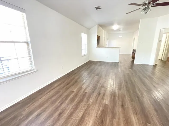 a view of a room with wooden floors and white walls