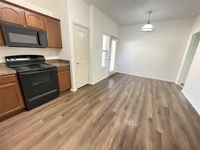 a kitchen with granite countertop a stove and a microwave oven