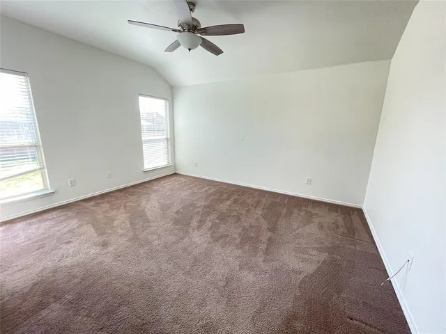 an empty room with windows and fan