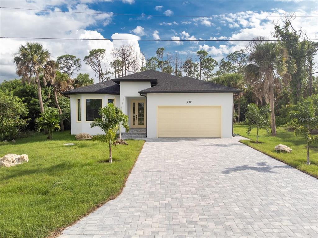289 Albatross Road Rotonda West, FL 33947 - Photo 1 of 30 a front view of a house with a yard and garage