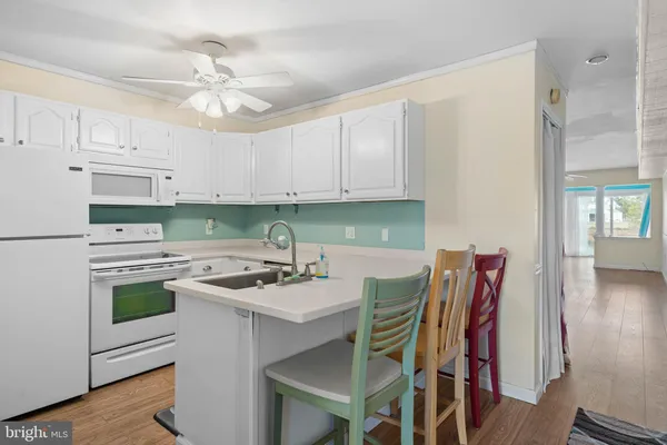 a kitchen with stainless steel appliances kitchen island granite countertop a table chairs sink and cabinets