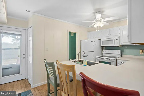 a kitchen with stainless steel appliances a white table chairs and a refrigerator