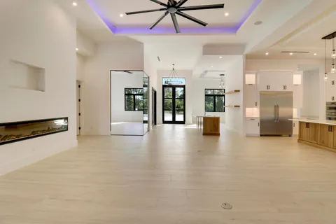 an empty room with a ceiling fan and window