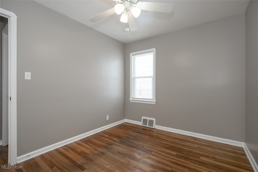 12328 Granger Road Cleveland, OH 44125 - Photo 14 of 37 Unfurnished room with dark wood-style flooring and ceiling fan