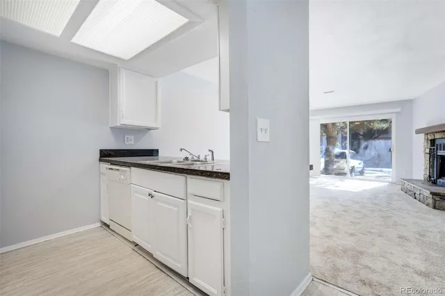 a view of kitchen with granite countertop cabinets and window