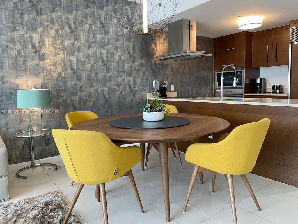 485 Brickell Avenue, Unit 3607 Miami, FL 33131 - Photo 2 of 36 a kitchen with a table chairs and a dining table