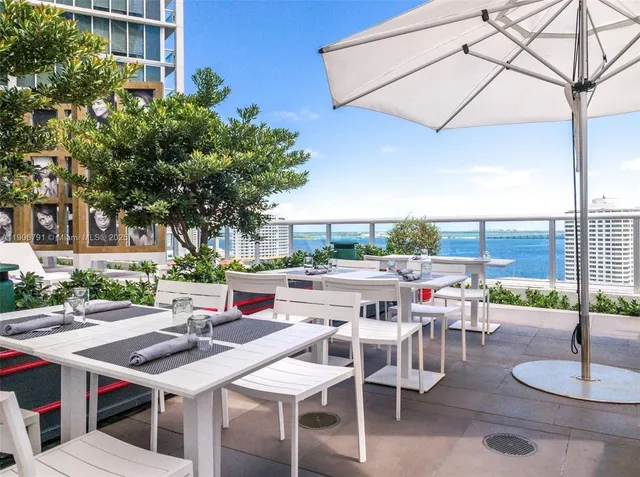 a view of a patio with a table and chairs and potted plants