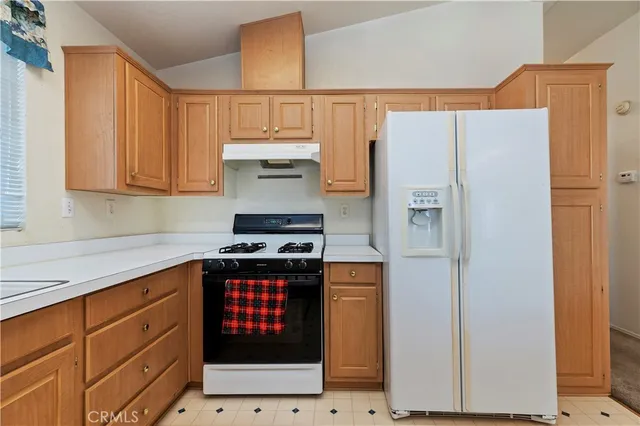 a kitchen with stainless steel appliances a refrigerator a stove a sink and cabinets