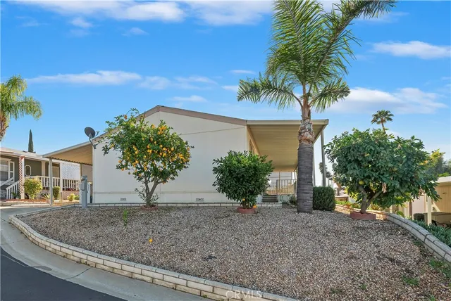 a view of a house with a yard and palm trees