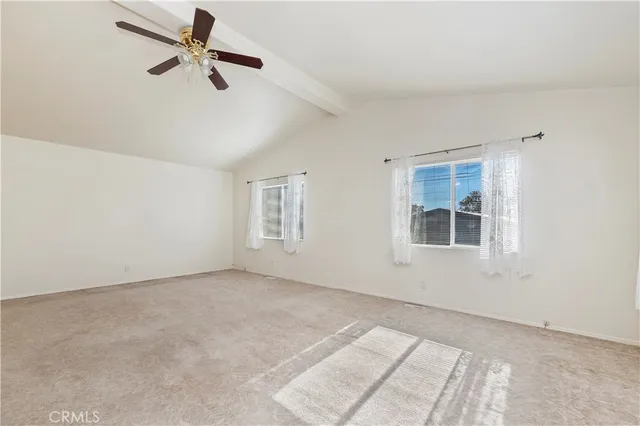 a view of a big room with windows and ceiling fan