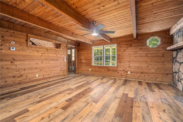 a view of empty room with a window and wooden floor