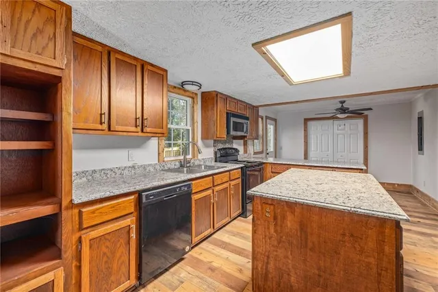 a kitchen with stainless steel appliances granite countertop refrigerator sink and cabinets