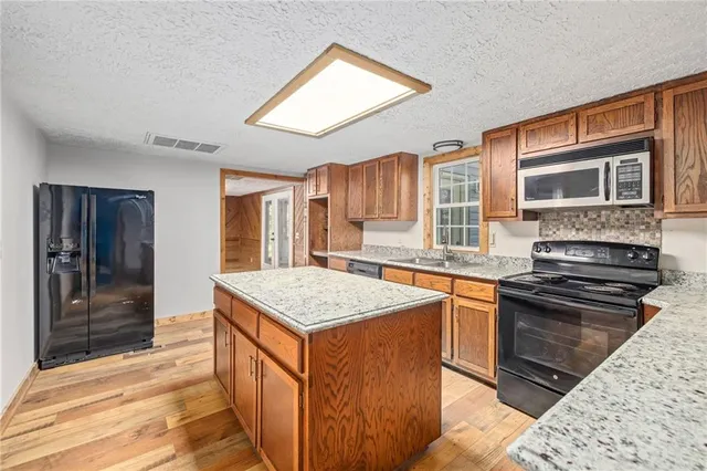 a kitchen with stainless steel appliances granite countertop a sink stove and refrigerator