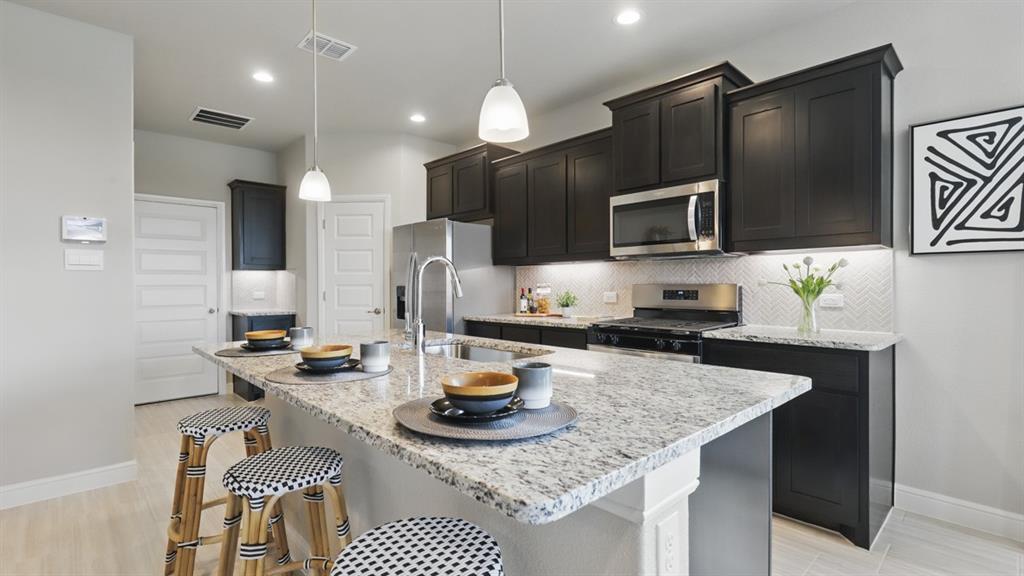 a kitchen with sink a microwave a stove and refrigerator