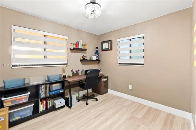 a view of a workspace with furniture and a window