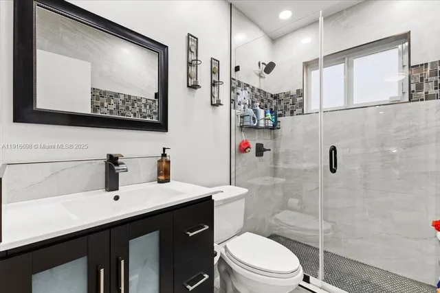 a bathroom with a sink vanity mirror and toilet