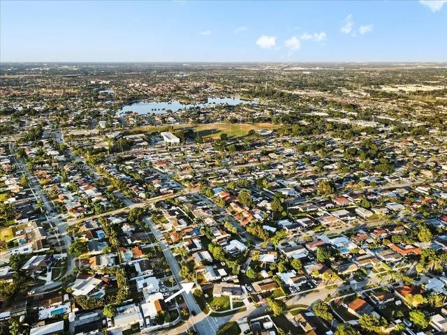 an aerial view of residential houses with outdoor space and trees