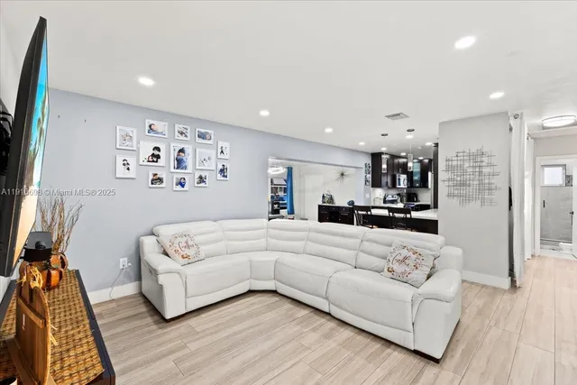 a view of a living room kitchen with furniture and wooden floor
