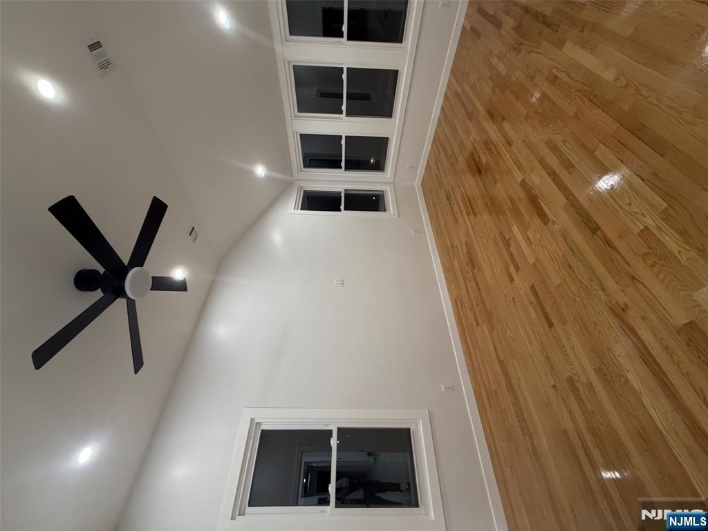 40 Elder Avenue, Unit 2 Bergenfield, NJ 07621 - Photo 4 of 9 an empty room with wooden floor and windows