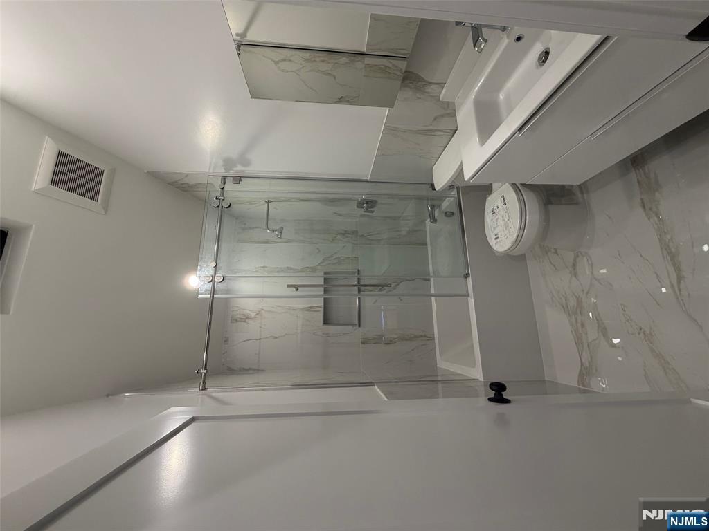 40 Elder Avenue, Unit 2 Bergenfield, NJ 07621 - Photo 8 of 9 a bathroom with a sink a toilet and shower