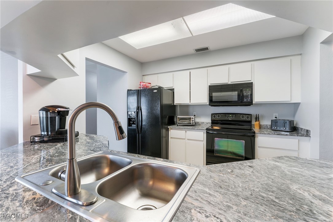 950 Moody Road, Unit 124 North Fort Myers, FL 33903 - Photo 19 of 44 a kitchen with a refrigerator sink and wooden cabinets