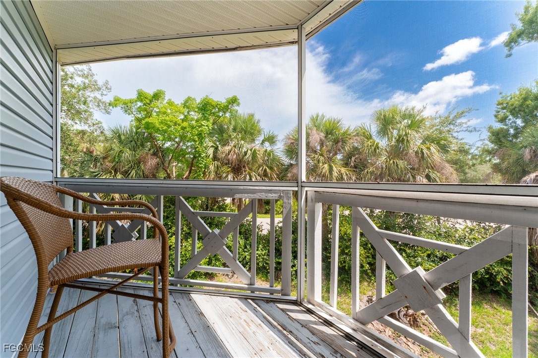 950 Moody Road, Unit 124 North Fort Myers, FL 33903 - Photo 22 of 44 a view of a balcony with chairs and wooden floor