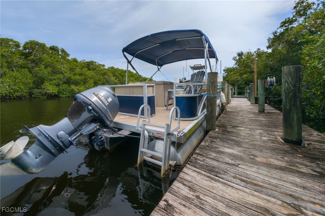 950 Moody Road, Unit 124 North Fort Myers, FL 33903 - Photo 4 of 44 a view of a roof deck with table and chairs under an umbrella with wooden floor
