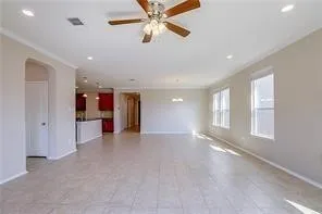 an empty room with windows and ceiling fan