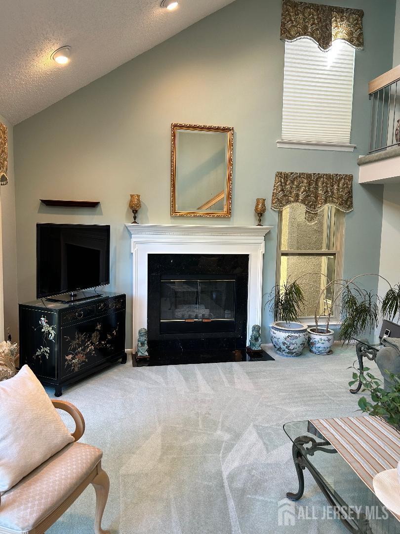 75 Kelly Drive Edison, NJ 08820 - Photo 12 of 41 a living room with furniture a flat screen tv and a fireplace