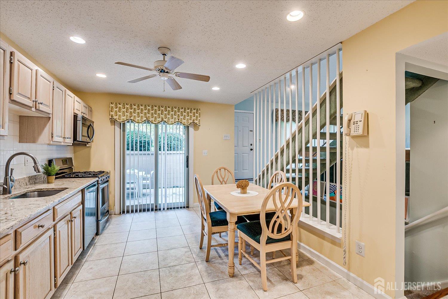 75 Kelly Drive Edison, NJ 08820 - Photo 16 of 41 a dining hall with stainless steel appliances granite countertop a sink a stove a refrigerator with a dining table and chairs