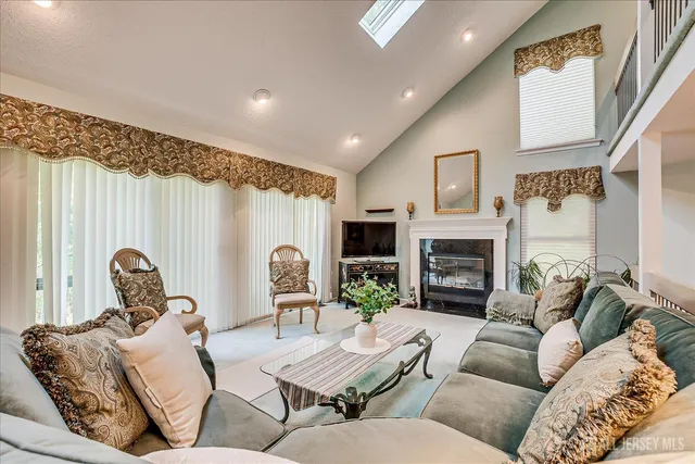 a living room with furniture fireplace and a large window