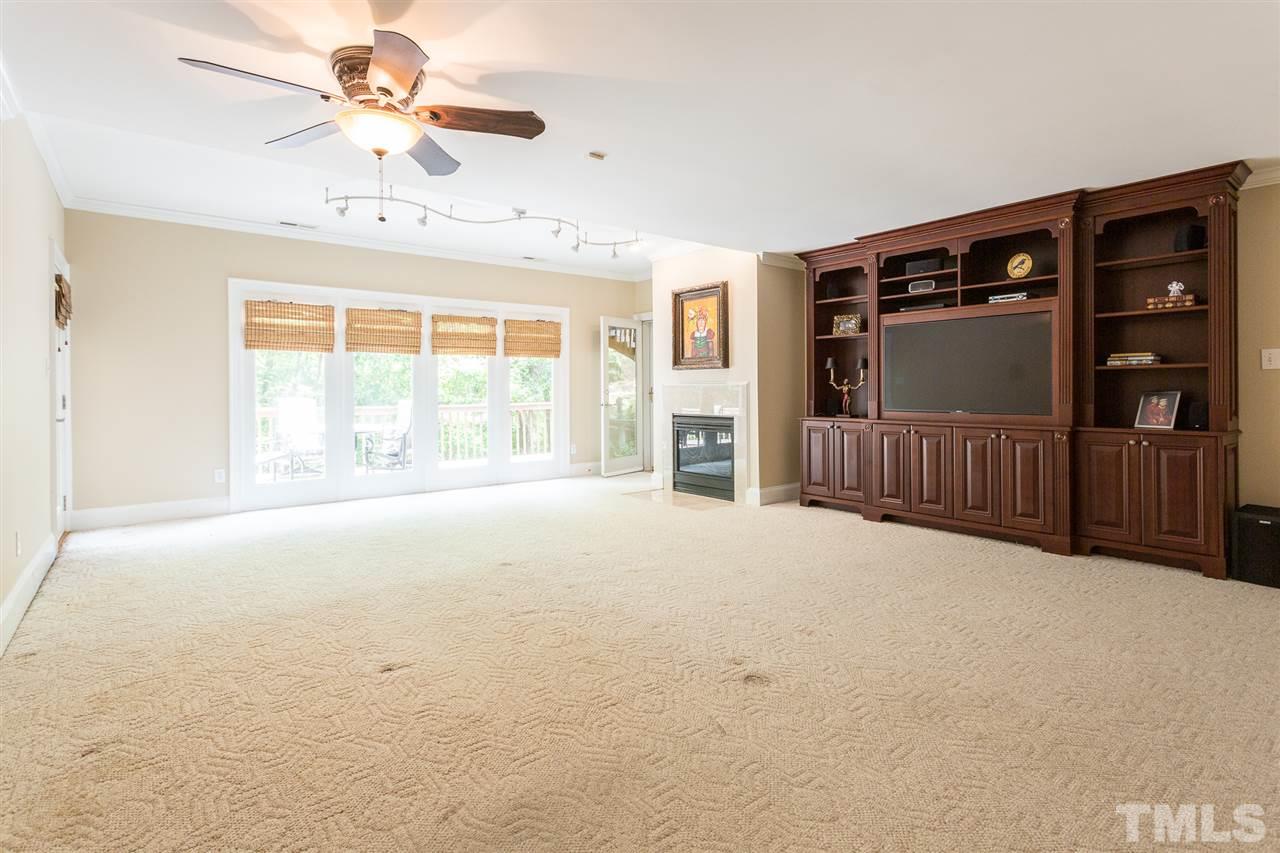 1001 Clingmans Place Raleigh, NC 27614 - Photo 22 of 30 Lower level provides large recreation room w/gas fireplace, wall of windows overlooking backyard, luxurious remodeled full bath, built-in cabinet w/beverage fridge 2 bedrooms, exercise room,& grand custom designed closet. (wall cabinet doesn't convey)