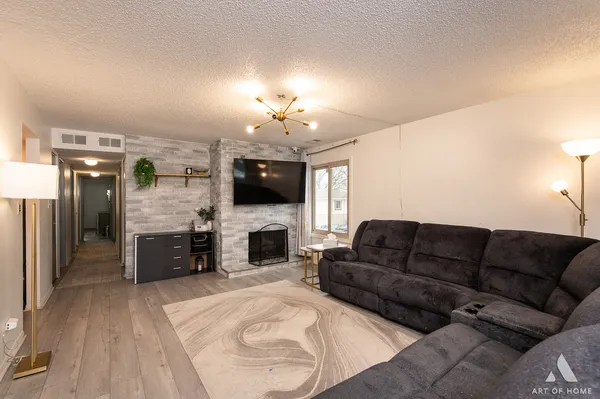 a living room with furniture a fireplace and a flat screen tv