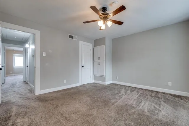 a view of an empty room with a ceiling fan