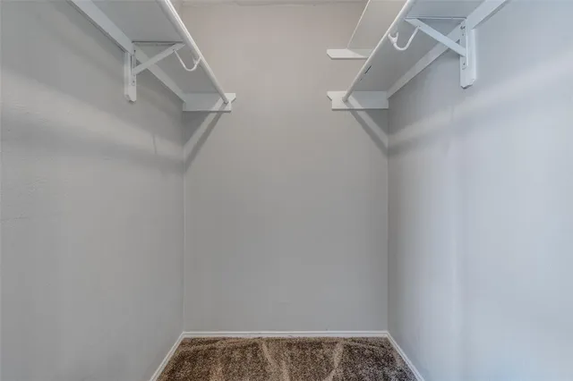 an empty room with closet a chandelier fan and a living room