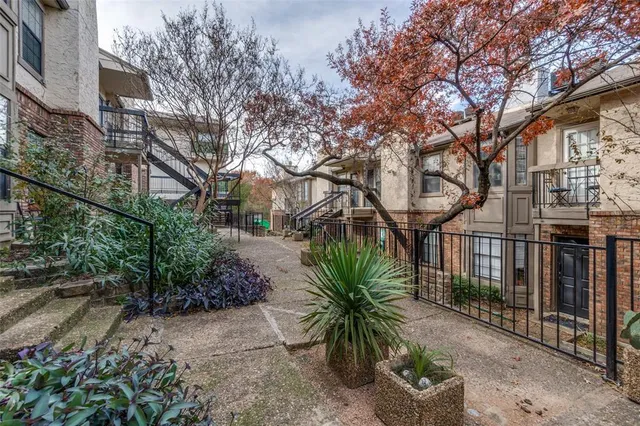 a view of a street with brick building and large tree