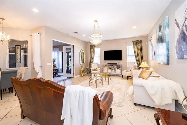 a living room with furniture a flat screen tv and a chandelier