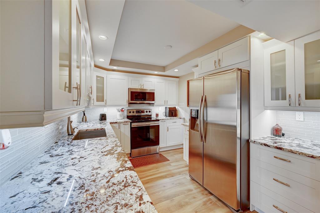 a kitchen with stainless steel appliances a refrigerator sink and stove