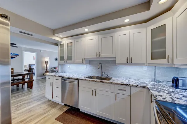 a kitchen with stainless steel appliances granite countertop a sink stove and cabinets